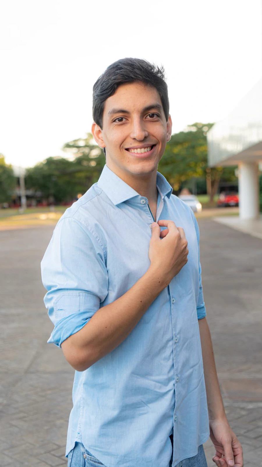 Gustavo Mota, psicólogo clínico, sorrindo, de camisa azul clara, ao ar livre